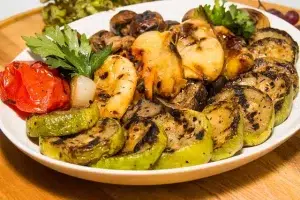 Plato con alimentos típicos de la dieta mediterránea: aceite de oliva, pescado azul, verduras, frutas, legumbres y pan integral. Alimentación saludable y equilibrada.